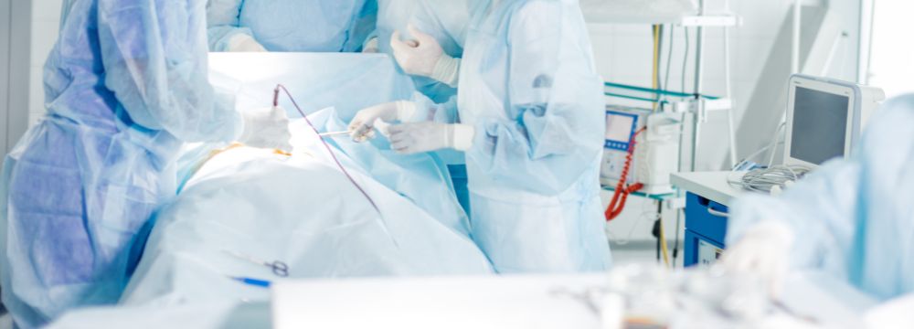 Operating room scene with doctor at the operating table performing penile implant on patient