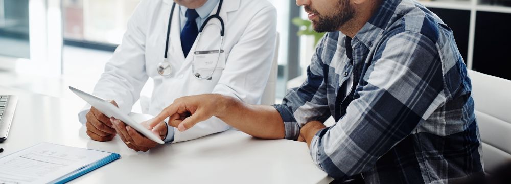 Male patient consulting with doctor, looking over BPH treatment options